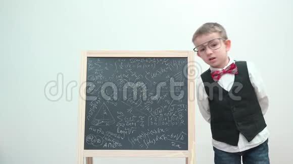 带着眼镜和制服的滑稽孩子把脸贴在粉笔板上取笑学习视频的预览图