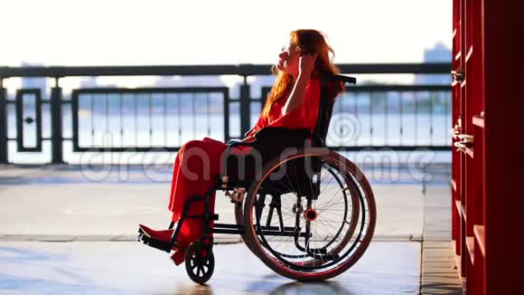 美丽的红发女孩坐在轮椅上走出书架视频的预览图