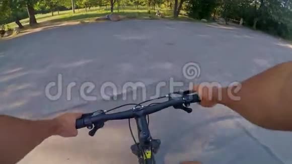 阳光明媚的夏日公园里的手控车轮自行车视频的预览图
