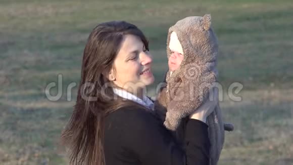 年轻的妈妈抱着一个刚出生的小玩具熊孩子看着镜头视频的预览图