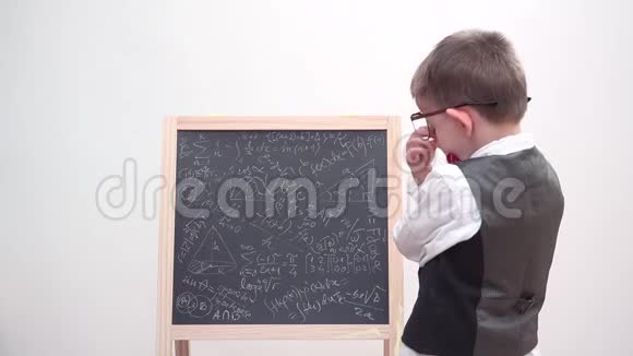 有趣的孩子专注于粉笔板与数学潦草疲惫的学生与眼镜和制服沉重的学习视频的预览图