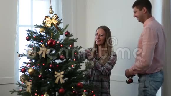 幸福的夫妻装饰圣诞树视频的预览图