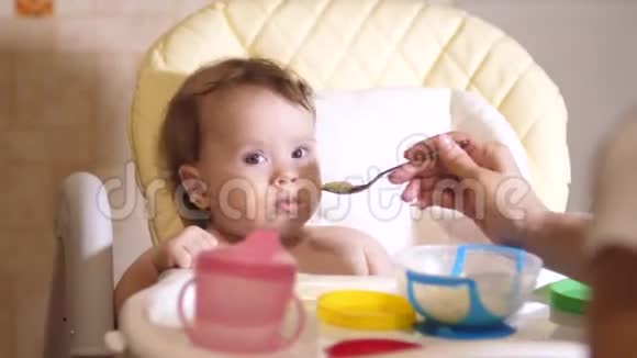 小宝宝坐在厨房的椅子上吃粥视频的预览图