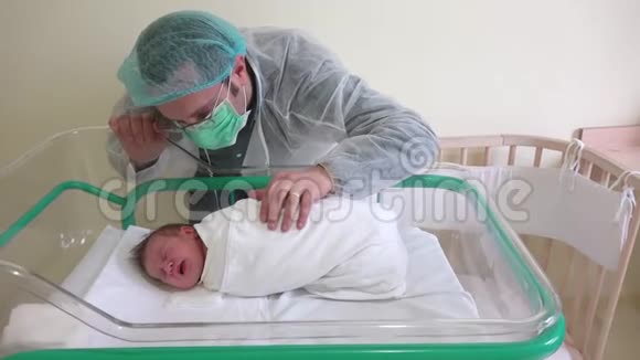 情绪激动的年轻父亲爱抚新生儿婴儿在医院里睡觉视频的预览图