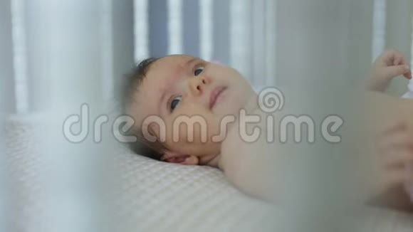 可爱的小宝宝躺在家里的床上视频的预览图
