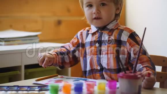 可爱认真专注的男孩绘画可爱的小男孩在他的相册里画画幼儿教育概念视频的预览图