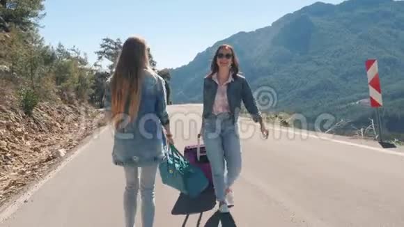 两个年轻女孩走在路上有着美丽的自然景观视频的预览图