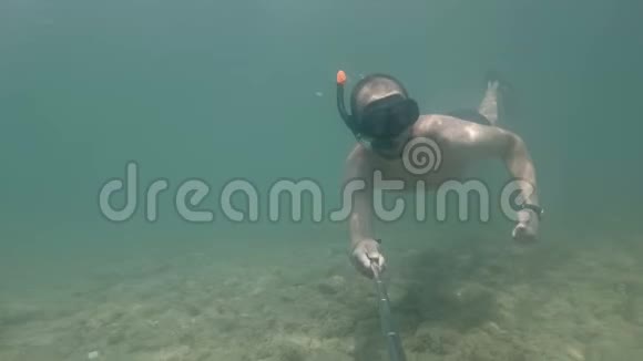 男人潜水在水下自拍向你挥动他的手视频的预览图