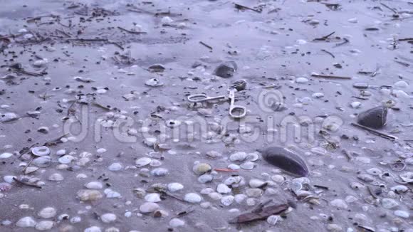 铁剪落在沙滩上的湿沙上视频的预览图