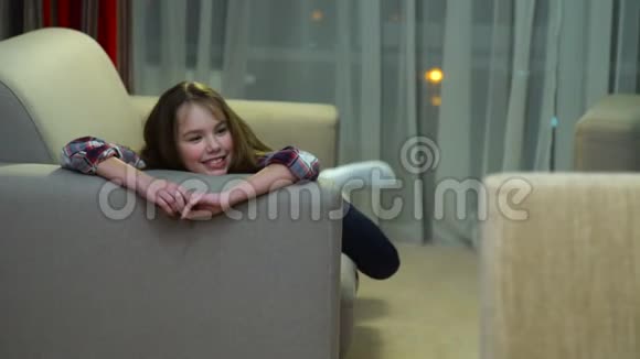 孩子闲闲的女孩躺在沙发上聊天视频的预览图