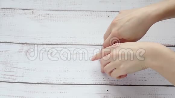 孩子和妈妈的手特写在一张木桌的背景下放慢了脚步手指视频的预览图
