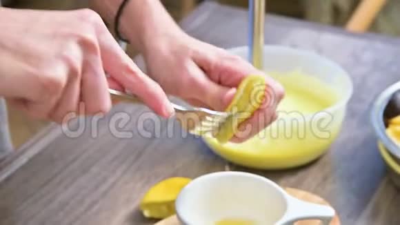 在家庭厨房的切割板上特写的女性双手捏着杯子里的柠檬视频的预览图
