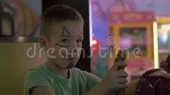 一个男孩脸上画着猫鼻子在玩游戏机视频的预览图
