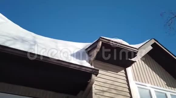 屋顶的小屋或住宅社区的屋顶下的雪屋顶上飘着雪在雪中和胜利中视频的预览图