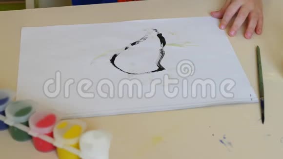 幼儿手在坐在桌旁的一张白纸上画水彩特写镜头视频的预览图