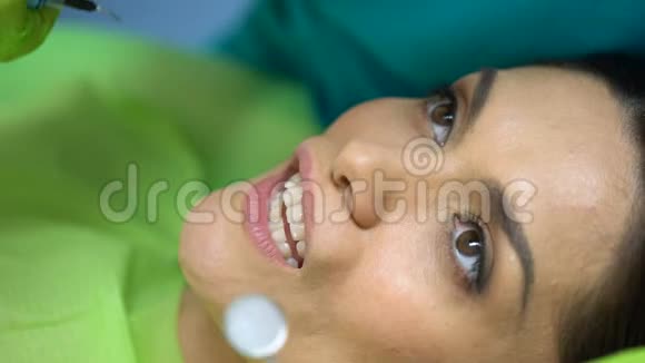 牙科医生在牙齿上使用蓝色凝胶模型膏牙科美容特写视频的预览图