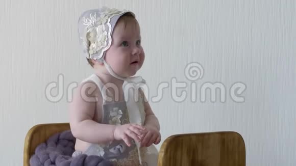 摄影穿着帽子和衣服的婴儿坐在木箱里对着镜头摆姿势视频的预览图