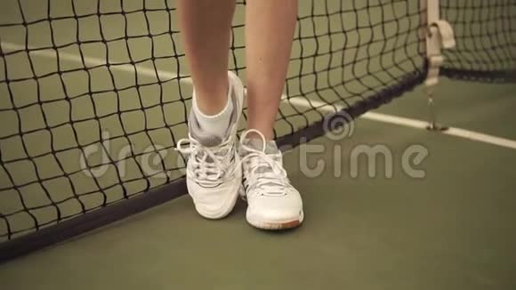 一名年轻的运动女网球运动员站在网附近从底部向上的慢镜头视频的预览图