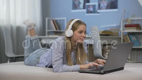少女听音乐在社交网络中交流使用笔记本电脑视频的预览图