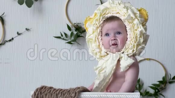 微笑的幼儿戴着头饰坐在摄影特写镜头的木制姿势上视频的预览图