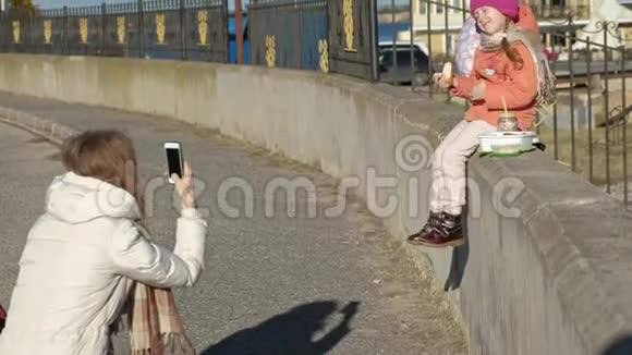 一个女人带着一个女孩一个母亲带着一个女儿在河港一个女人拍一个孩子的照片一个孩子微笑视频的预览图