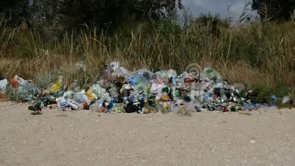 在海边的海滩上撒了垃圾空用过的脏塑料瓶肮脏的海洋沙质海岸黑海视频的预览图