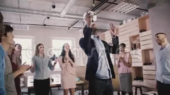 快乐黑人队队长在头上踢足球第40代创业公司员工庆祝办公室慢动作成功视频的预览图