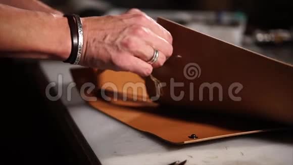 用皮革制造配件的大师手的特写镜头视频的预览图