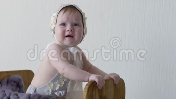 一个穿着头饰的小女孩坐在木箱里在镜头上摆姿势拍照视频的预览图