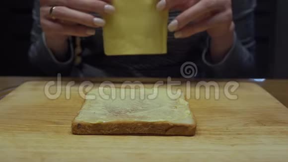 女人在面包和黄油上放了一片奶酪视频的预览图