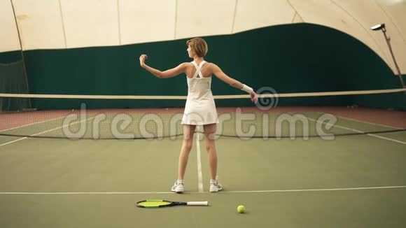 背面慢动作镜头一位年轻的运动女网球运动员短发金发穿着白色运动服视频的预览图