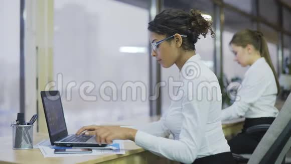 漂亮的混血女人比较财务状况勤奋的女性办公室视频的预览图