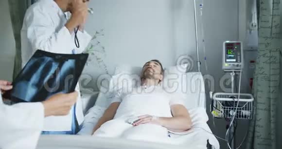 年轻医生在病床上检查病人4k视频的预览图