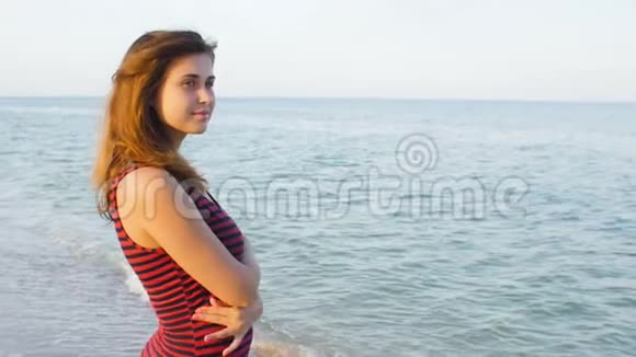 浪漫的女孩走在海滩上年轻的女人在海边享受海浪和风的声音概念暑假生活视频的预览图