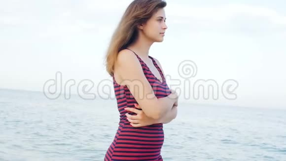 浪漫的女孩走在海滩上年轻的女人在海边享受海浪和风的声音概念暑假生活视频的预览图