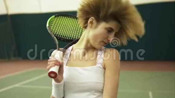 年轻的女网球运动员金发短发在网球场摇头玩得很开心休闲时间视频的预览图