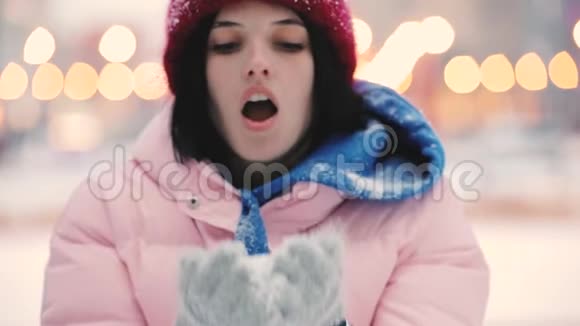 快乐的女人在冬天吹雪慢动作视频的预览图