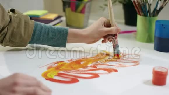年轻的女艺术家用画笔按桌作画视频的预览图