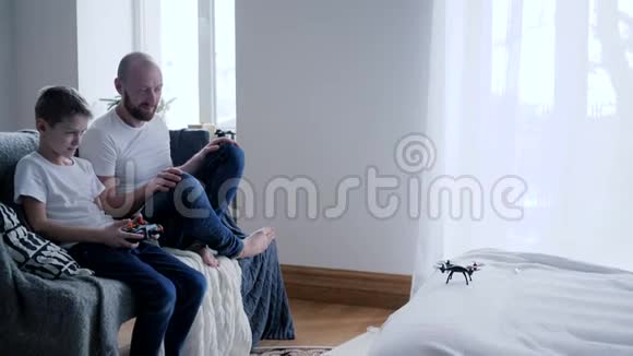 爸爸和儿子在卧室里慢动作地玩现代玩具无人机视频的预览图