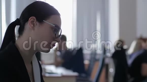 工作过度的女孩在办公室的特写镜头后面坐着电脑键盘打字视频的预览图