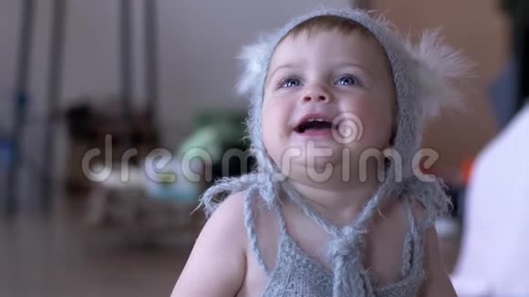 婴儿的乐趣快乐的蹒跚学步的孩子穿着花哨的衣服在不集中的背景上笑视频的预览图