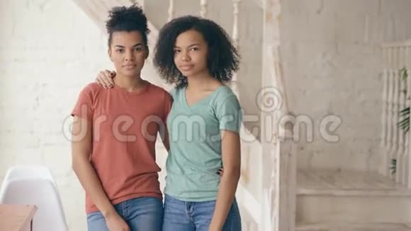 两个美丽的非裔美国女孩笑着看着镜头的肖像女人从她脸上流露出情感视频的预览图