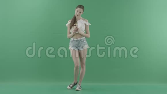 女人在绿色背景下摆着鸡尾酒视频的预览图