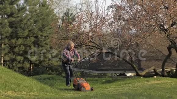 成年男子电动割草机割草机园丁修剪花园视频的预览图
