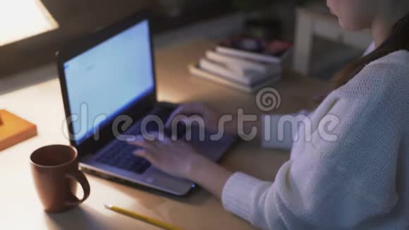 一位自信的妇女在图书馆里用笔记本电脑做她的项目视频的预览图