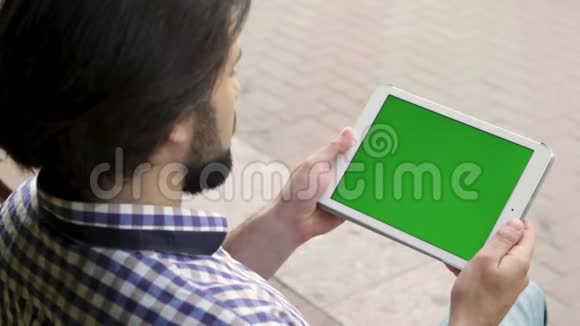 男人坐着手里拿着垫子然后他开始在屏幕上滑动三次是绿色的那么人就是视频的预览图