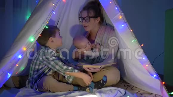 家庭休闲妈妈晚上给两个儿子读童话故事视频的预览图