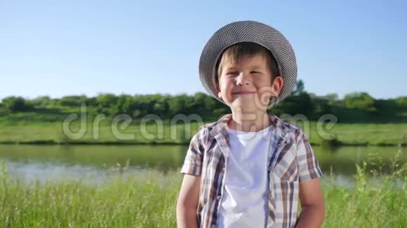 微笑的孩子手里拿着一杯水在洛夫附近的绿色草坪上视频的预览图