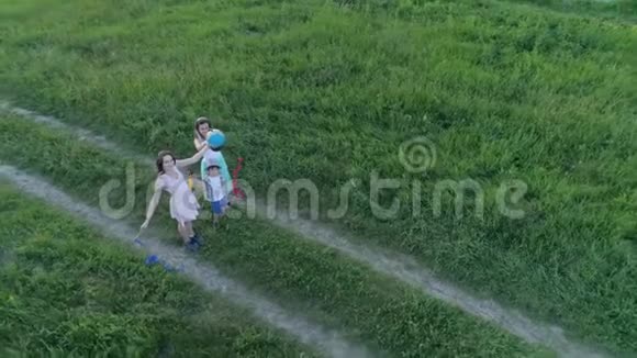梦想旅行幸福的家庭在无人驾驶的视野中把地球仪举到草地上视频的预览图