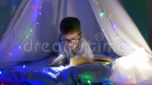 在黑暗中睡觉前聪明的孩子戴上带手电筒的眼镜视频的预览图